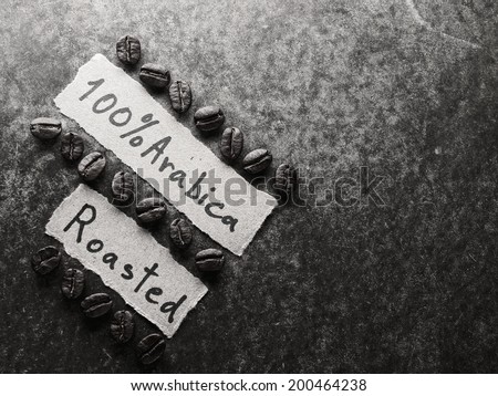 Coffee crop beans with text paper on wood texture, monotone  background