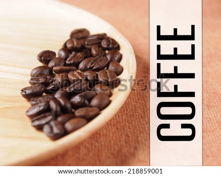 Coffee crop beans with coffee banner label on wood plate and fabric texture background