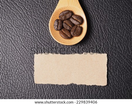 Coffee crop beans on bamboo spoon and leather texture background