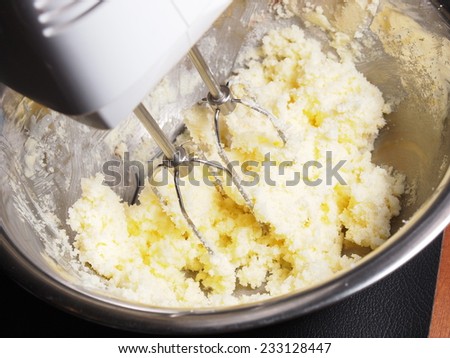 Mixing butter and sugar in bowl with mixing machine, making bakery
