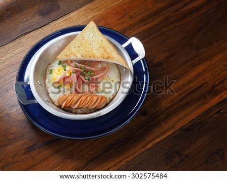 Sunny Side Up egg with sausage ham and garlic bread