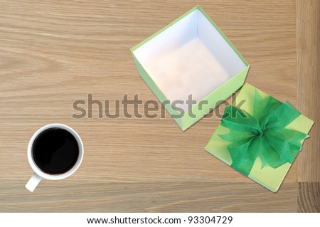 green gift box on table with coffee