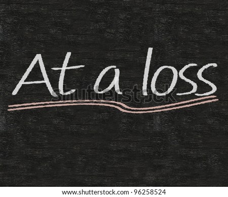 business idioms written on blackboard background, at a loss