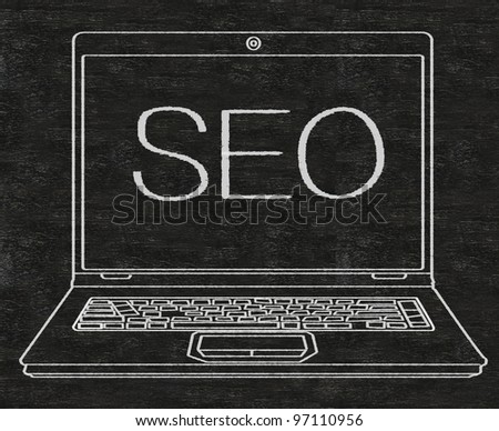 Search Engine Optimization SEO written on computer screen on blackboard background
