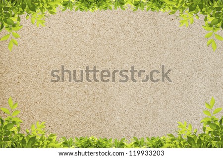 Green leaves frame isolated on texture of recycled paper background.