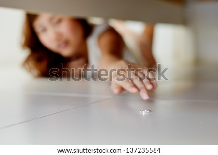 Woman searching diamond ring under her bed