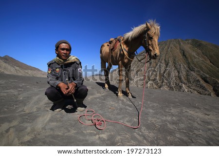 JAVA,INDONESIA-September 19:Unidentified man with the horse for tourist rent at Mt.Bromo on September 19,2012 in Indonesia.Mt. Bromo is an active volcano and part of the Tengger massif, in East Java.