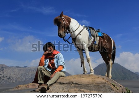 JAVA,INDONESIA-May 11:Unidentified man with the horse for tourist rent at Mount Bromo on May 11,2013 in Java , Indonesia.Mt. Bromo is an active volcano and part of the Tengger massif, in East Java.