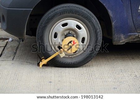 Bangkok, Thailand - June 11: Wheel lock on an illegally parked car in Bangkok, Thailand on June 11, 2014.The measure was implemented during rush hour - 6am to 9am and 3pm to 6pm.