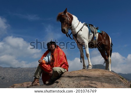 JAVA,INDONESIA-May 11:Unidentified man with the horse for tourist rent at Mount Bromo on May 11,2013 in Java , Indonesia.Mt. Bromo is an active volcano and part of the Tengger massif, in East Java.