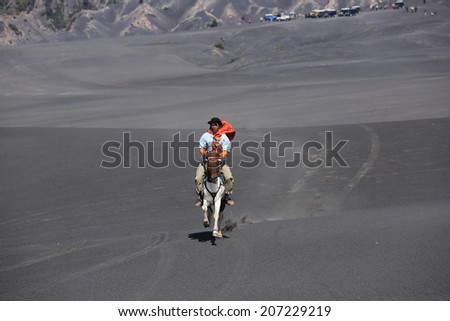 The horsemen in Bromo , Indonesia on May 12,2013 : An unidentified horsemen riding horse at edge of volcano . The volcano east Java sometime erupt and let out a flood of lava beach.