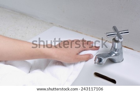 Cleaning Sink , female hand drying off kitchen sink with  towel