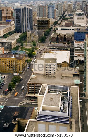 Bird view at a modern large city with small church among highrise buildings