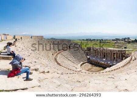PAMUKKALE, TURKEY - April 16: Tourists watching the ancient theater of the Roman city of Hierapolis on April 16, 2014 in Pamukkale, Turkey. The site is a UNESCO World Heritage site