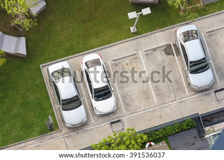 Top view of parking area with small garden in modern building