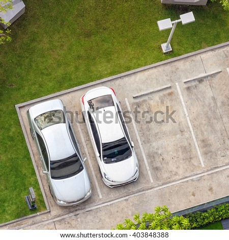 Top view of parking area with small garden in modern building