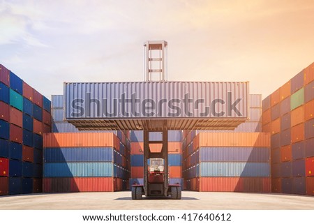 Forklift truck lifting cargo container in shipping yard for transportation import,export, logistic industrial with container stack in background