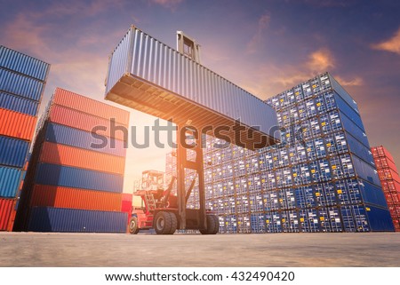 Forklift truck lifting cargo container in shipping yard or dock yard against sunrise sky with cargo container stack in background for transportation import,export and logistic industrial concept