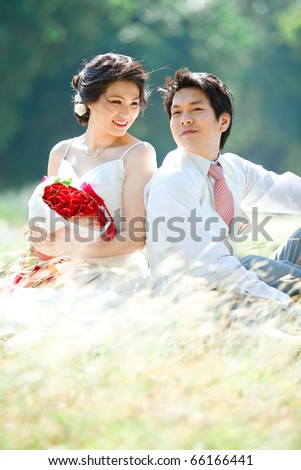 Bride and groom make eyes contact on dry grass field