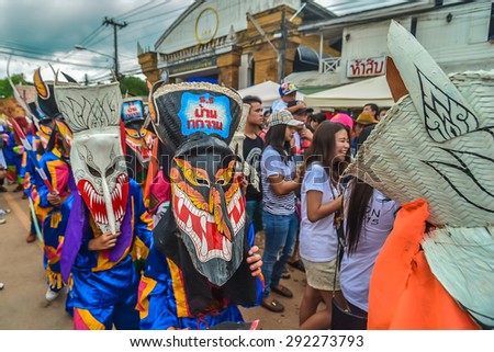 Loei, Thailand - June 27, 2015 : People are dressing with colorful clothes and put the hand made mask which made from wood or threshing bamboo in ghost mask festival or 