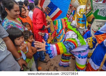 Loei, Thailand - June 27, 2015 : People are dressing with colorful clothes and put the hand made mask which made from wood or threshing bamboo in ghost mask festival or \