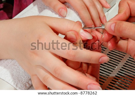 Master correcting the nails of a woman
