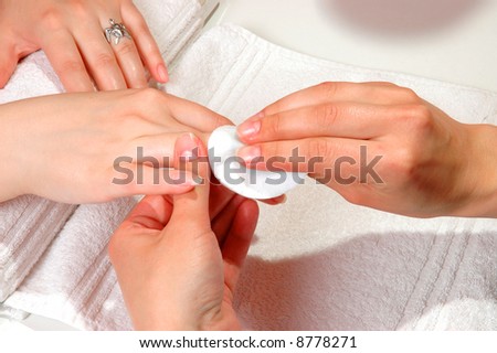 Master cleaning the nail of a woman