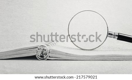 search through a book by magnifying glass (paper textured effect)