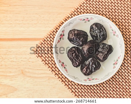 Ajwa Dates fruit on wooden table (Ajwa is a soft dry variety of date fruit from Saudi Arabia. It is cultivated at the city of Madinah)