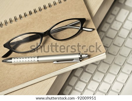 glasses, pen and book for memo on working desk