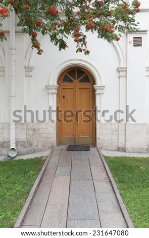 A brightolddoor of a stone church with stone walkway, focus on door