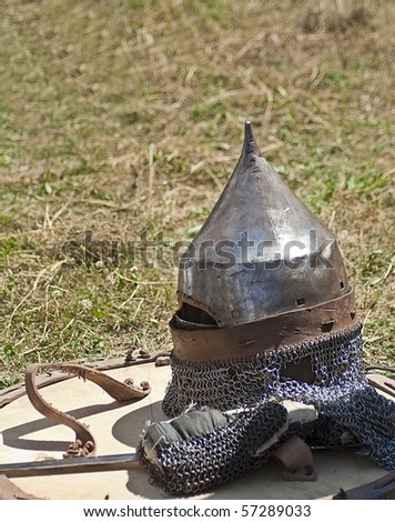 Medieval helmet with shield laying on the ground
