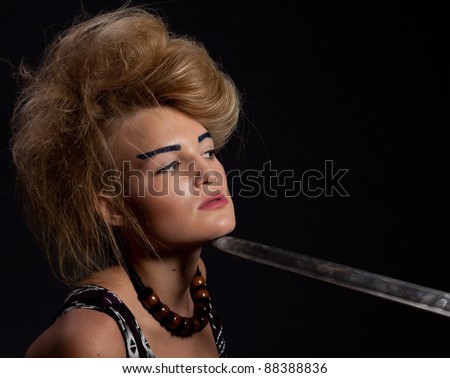Young warrior woman holding sword in her hand, studio shoot.