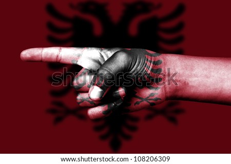 human hand point with finger in albanian national flag