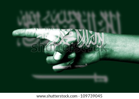 Human hand point with finger in Saudi Arabia national flag