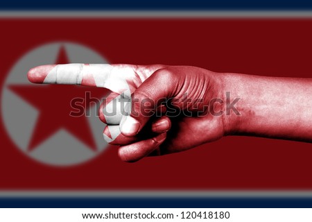 Human hand point with finger in North Korea national flag