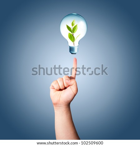 Man hand pointing to light bulb with green plant inside. Concept for idea for environmental conservation