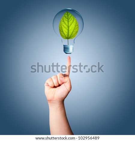 Man hand pointing to light bulb with green plant inside. Concept for idea for environmental conservation