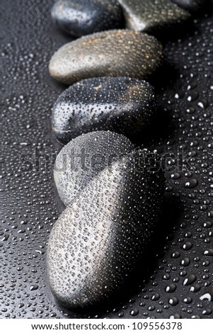 Black stone and water drop, with shallow depth of field
