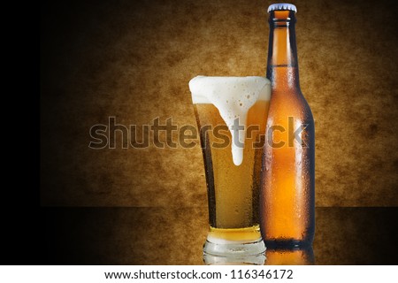 A glass of beer and beer bottle on yellow background