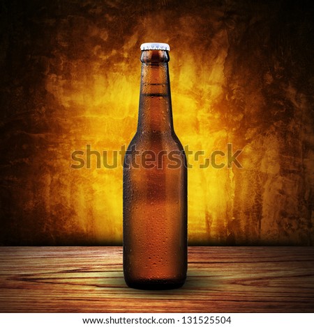Bottle of cold beer on wood table with yellow grunge background