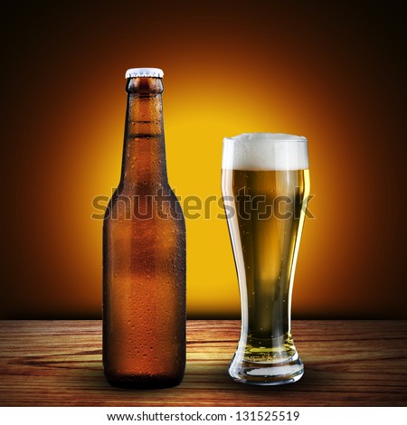 Bottle and Glass of cold beer on wood table with yellow grunge background