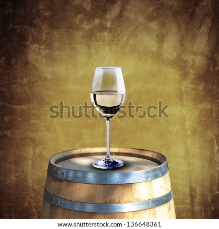 White wine glass on wood barrel with grunge background