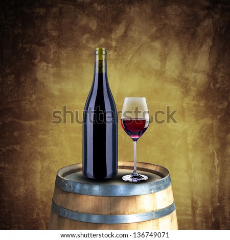 Red wine bottle and glass on wood barrel with grunge background
