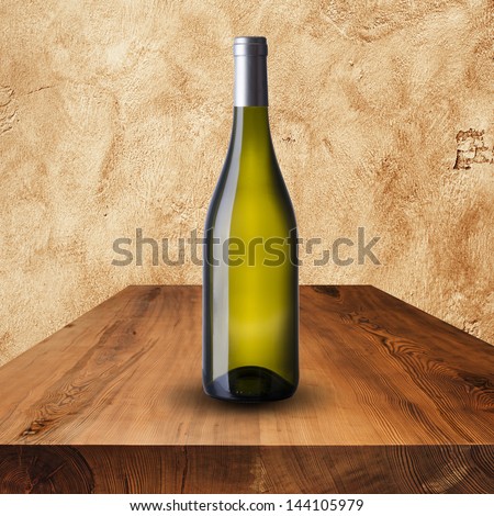 Bottle white wine on wood table and grunge wall