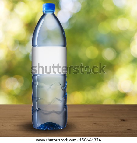 Bottle of drinking water with blank label on wood table