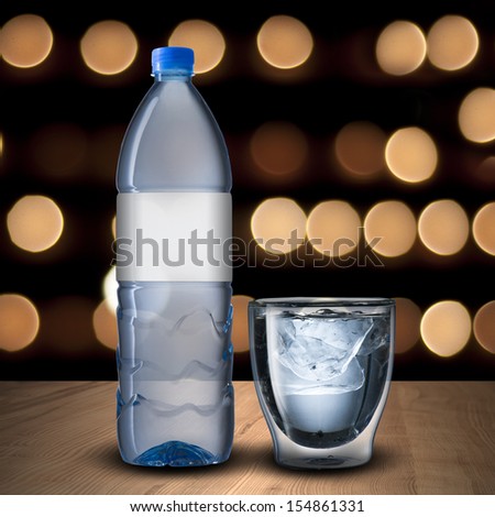 Glass and bottle of water with bokeh background