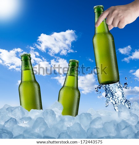 Cold Beer Bottle in Ice Cubes in Hot Summer Day