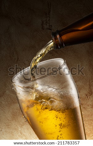 Beer pour into glass with grunge background