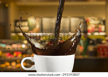 Coffee Splash from Cup With Coffee Shop in Background